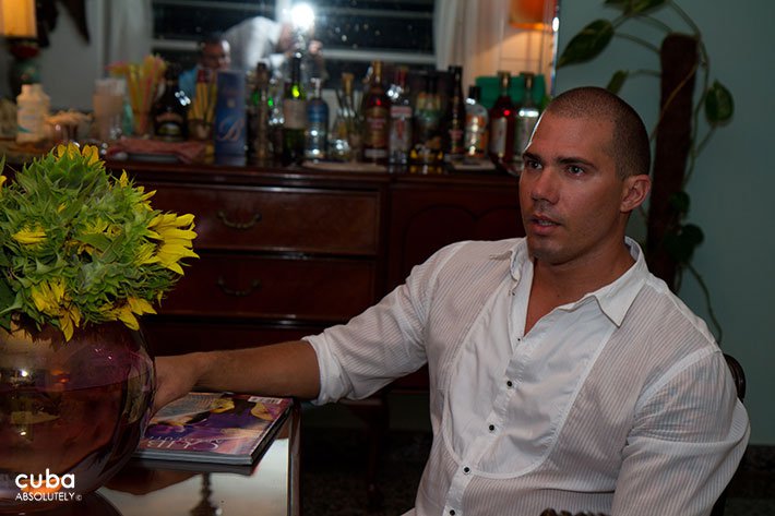 Man with a white shirt sitting on a chair © Cuba Absolutely, 2014